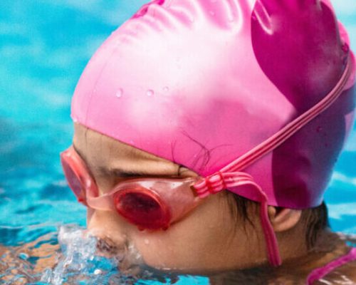 Group of children on swimming class, making bubbles